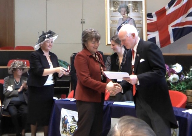 Elizabeth Harper Receiving British Citizenship Certificate From Deputy Lord-Lieutenant, Peter Davies