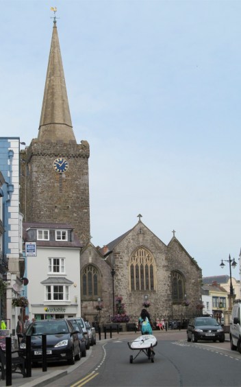 Woman Pulling Surfboard Behind Bicycle